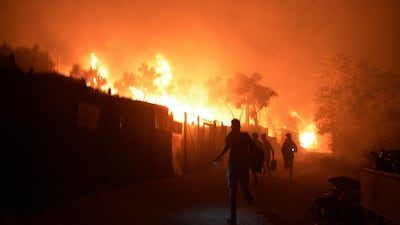 Refugees run as fire burns in the Moria camp on the northeastern Aegean island of Lesbos, Greece. AP Photo