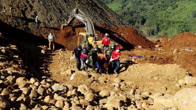 Soldiers and rescue workers carry the body of a dead miner killed by landslide at Hpakant jade mining area, Kachin State, northern Myanmar as the death toll rose to more than 100 with another 100 still missing. Handout from MWD daily news/EPA