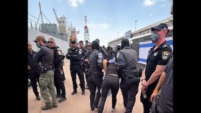 A detained activist from the Gaza-bound aid flotilla is escorted away by security forces in a screengrab from footage released on Israeli National Security Minister Itamar Ben-Gvir’s X account