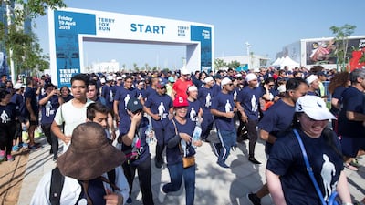 Runners stream over the starting line on Friday morning.