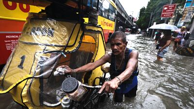 Filipinos wade through floodwater in Manila, the Philippines. EPA
