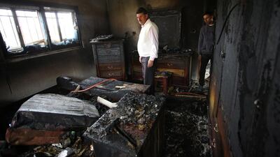 Palestinians inspecting the damage at the burned house of Ibrahim Dawabsha, from the West Bank village of Duma on 20 March 2016. Mr Dawabsha is a key witness in the firebombing attack carried out by Jewish extremists on July 2015 against his relatives which kiled an 18-month-old boy along with his two parents. EPA