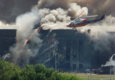 A rescue helicopter surveys damage to the Pentagon in Washington as firefighters battle the flames on September, 11 2001. Reuters