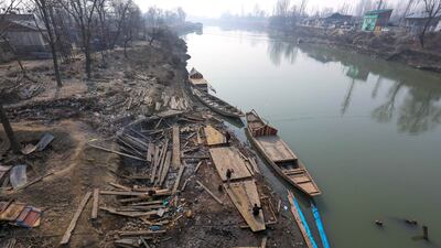 Kashmiri men repair a house boat on the Jhelum River, taking advantage of the dry spell. EPA