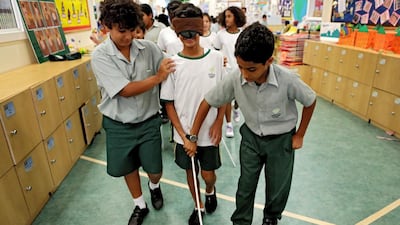 Saif Al Mubarak, 10, left, guides Saeed Al Mehairbi, also 10, as they take part in an exercise during Disability Awareness Week at Al Mushrif Primary School in Abu Dhabi to simulate what it would be like to be blind. Christopher Pike / The National