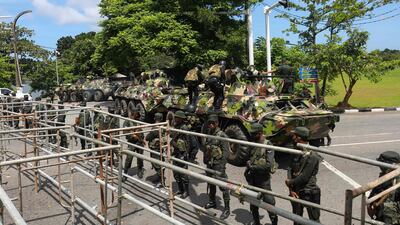 Sri Lankan soldiers stand guard near the parliament building in Colombo, a day after thousands of anti-government protesters stormed the prime minister's office. AFP