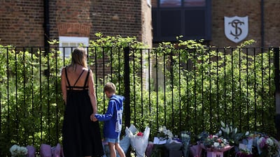 People leave floral tributes after a car crashed near a school in Wimbledon, killing one and injuring 15. Reuters
