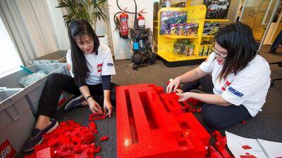 Lego staff members building blocks at the opening of the new Lego office. Leslie Pableo for The National