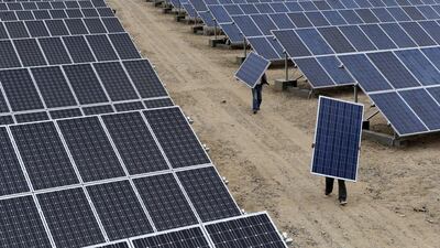 Kuwait is joining the global league of solar power producers, such as China, with its new plant. Here, employees carry panels at a plant in Aksu, China Courtesy Reuters