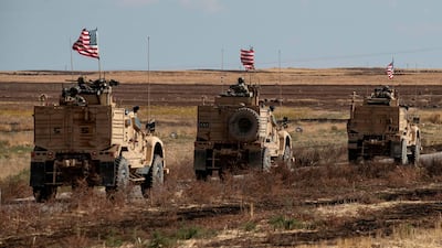 A convoy of US armoured vehicles patrols the northern countryside of the northeastern Syrian town of al-Malikiyah (Derik) at the border with Turkey, on November 3, 2019. / AFP / Delil SOULEIMAN