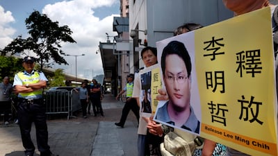 A protester raises a picture of Taiwanese activist Lee Ming-che during a demonstration outside the Chinese liaison office in Hong Kong on September 11, 2017. Vincent Yu / AP Photo