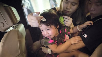 A young girl is treated by a medic in the back of Chen's car after being effected by tear gas during protests in the Mong Kok area of Hong Kong. 'School Buses', are the collective name to a group of volunteers, including Chen (not his real name), who offer free transport for people who need help getting away from the protests safely. Rick Findler for The National