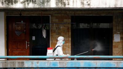 A Red Cross personnel wearing a protective suit sprays disinfectant along a corridor in a densely populated neighbourhood area, amid the spread of the coronavirus disease (Covid-19) in Jakarta, Indonesia, April 4, 2020. Reuters