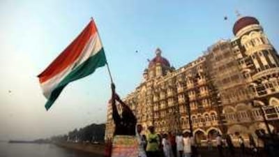 A man waves an Indian flag outside the Taj Mahal hotel, one of the sites of the terror attacks, on the first anniversary of the incident.