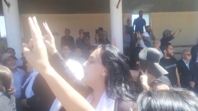 Druze women give the victory sign at Mr Al Jaramani's funeral