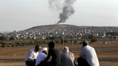 People watch while smoke rises from Syria's Kobani city on the Turkish-Syrian border, near Sanliurfa on October 3. EPA