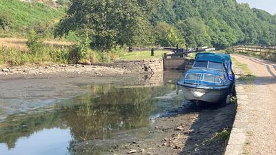A boat lies in the dried up Huddersfield narrow canal near Linthwaite in the Colne Valley, as a drought has been declared for parts of England following the driest summer for 50 years. PA