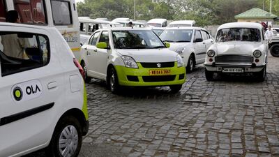 Ola cabs parked next to other cars. Ola drivers along with their Uber counterparts are on strike in the Indian capital for a fourth day. Bikas Das / AP