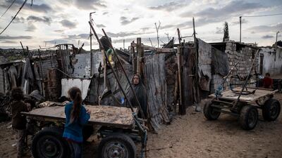 A Palestinian woman stands next to her house in a slum on the outskirts of Khan Younis Refugee Camp, in the southern Gaza Strip. AP Photo
