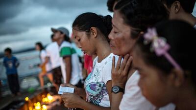 Catholic devotees read sections of the bible at a station of the cross on Calvery Hill on April 18, 2014 in Tacloban, Leyte, Philippines. Chris McGrath / Getty Images
