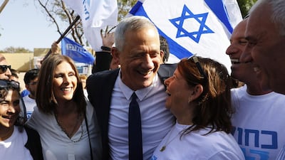 Retired Israeli general Benny Gantz, one of the leaders of the Blue and White political alliance, and his wife Revital greet supporters outside a polling station during Israel's parliamentary elections. AFP