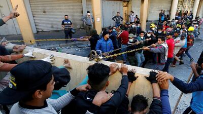 Demonstrators try to push down a concrete wall. Reuters