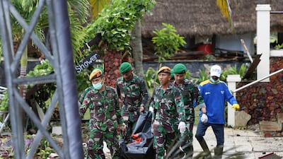 Indonesian soldiers and rescuers carry the bodies of victims at Tanjung Lesung beach resort. AP