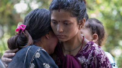 Relatives of flood victims stand outside the army base where survivors are brought by helicopters following a flash flood in Devighat Village, Nuwakot district, Nepal. EPA