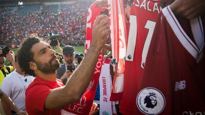 Liverpool's Mohamed Salah signs jerseys after the match. Reuters
