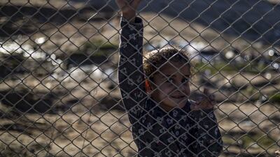 A child smiles from behind a fence at the Al Hol camp for the displaced in northeastern Syria. AFP