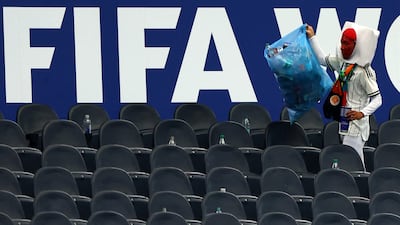 A Japan fan clears garbage from the stands. Reuters