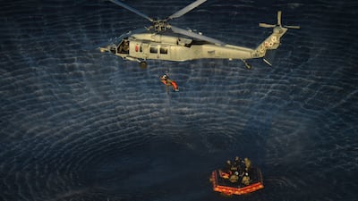 A helicopter transports a crew member to the recovery ship after being extracted from the Artemis II capsule. AFP