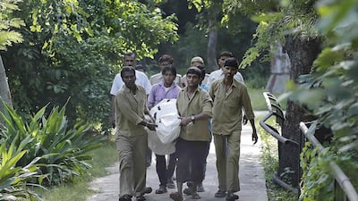 Zoo workers carry the body of a man who was mauled to death by a white tiger at the National Zoological Park in New Delhi on September 23, 2014. Anindito Mukherjee / Reuters