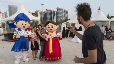 At Korean Festival on Abu Dhabi Corniche visitors from left Eunhye Kim and young Claire Christison, and Helena Houle with Eva Cary Brown with Korean mascots. Antonie Robertson / The National