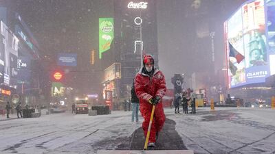 A worker clears snow as snow begins to fall in Times Square. Reuters