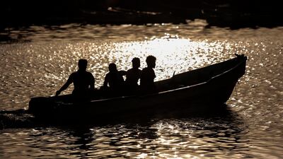 In this Sept. 29, 2018, photo, fishermen head out to sea for a fishing trip as the sun sets near the fishing port, in Hodeida, Yemen. (AP Photo/Hani Mohammed)