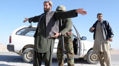An Afghan National Army soldier searches a passenger at a checkpoint on the way to the Sangin district of Helmand province, Afghanistan on December 23. Abdul Khaliq / AP Photos
