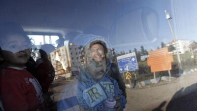 Children look through the window of a bus as they wait to enter Cizre, Turkey. Emrah Gurel / AP Photo