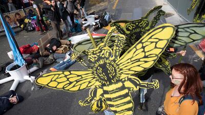 Protesters hold signs depicting bees during a demonstration called by climate change activist group Extinction Rebellion, on October 7, 2019 at the Place du Chatelet in Paris. AFP