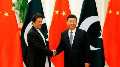 China's President Xi Jinping (R) shakes hands with Pakistan's Prime Minister Imran Khan (L) ahead of their meeting at the Great Hall of the People in Beijing. AFP