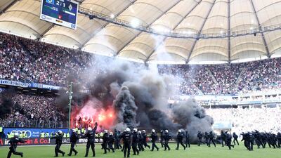 Police are seen as fans throw flares onto the pitch during the Bundesliga match between Hamburger SV and Borussia Moenchengladbach at Volksparkstadion in Hamburg, Germany, on May 12, 2018. Lars Baron / Bongarts / Getty Images