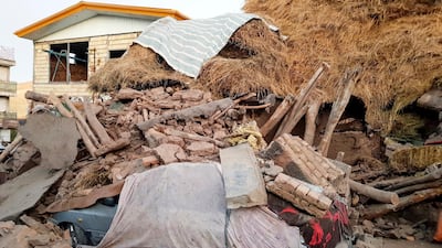 A car lays smashed by debris from an earthquake in Varankesh village in Eastern Azerbaijan province, some 400km northwest of the capital Tehran, Iran. Tasnim News Agency via AP