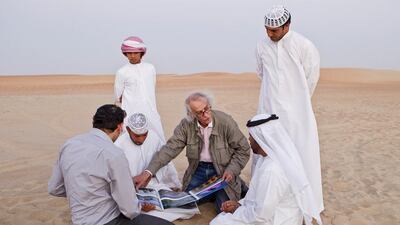 Christo meets with Liwa residents Khalfan Al Qubasi, left, Saeed Al Falahi, right, and Obaid Al Mazrouei, front right, in October 2012, to discuss his plans to construct 'The Mastaba', a pyramid of 410,000 barrels. Antonie Robertson / The National