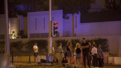 Residents and bystanders watch as Civil Defence crews fight the blaze high up on the Torch building. Antonie Robertson / The National