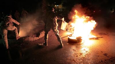 Lebanese soldiers remove tires that set on fire by protesters, during a protest against deteriorating living conditions and strict coronavirus lockdown measures, in Tripoli, Lebanon, Friday, Jan. 29, 2021. AP