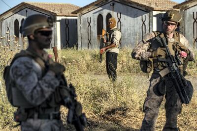 A member of Syrian Democratic Forces (SDF) (C) is accompanied by US soldiers on patrol in the countryside of the northeastern Syria. AFP