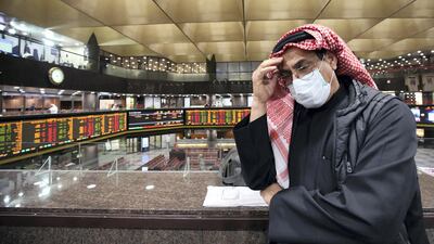 A Kuwaiti trader wearing a protective mask follows the market at the Boursa Kuwait stock exchange in Kuwait City on March 1, 2020. Boursa Kuwait decided to close the main trading hall due to the COVID-19 coronavirus disease developments. Stock markets in the oil-rich Gulf states plunged on March 1 over fears of the impact of the coronavirus, which also battered global bourses last week. All of the seven exchanges in the Gulf Cooperation Council (GCC), which were closed the previous two days for the Muslim weekend, were hit as oil prices dropped below $50 a barrel. The region's slide was led by Kuwait Boursa, where the All-Share Index fell 10 percent, triggering its closure. Kuwait's bourse was closed for most of last week for national holidays. AFP
