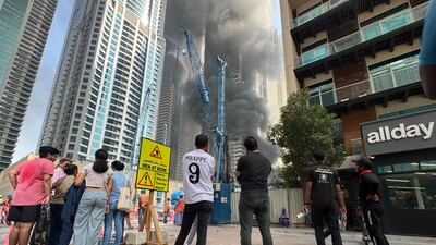 Members of the public look on as civil defence crews get to work on the Tiger building fire. Greg Tanner / The National