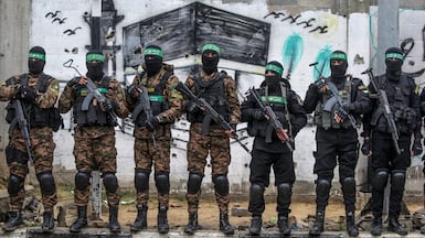 Hamas fighters stand guard during the handover of Israeli hostages in Al Nuseirat refugee camp, central Gaza, in February 2025. EPA