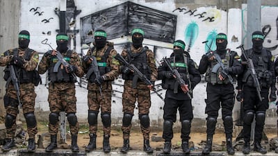Hamas fighters stand guard during the handover of Israeli hostages in Al Nuseirat refugee camp, central Gaza, in February 2025. EPA